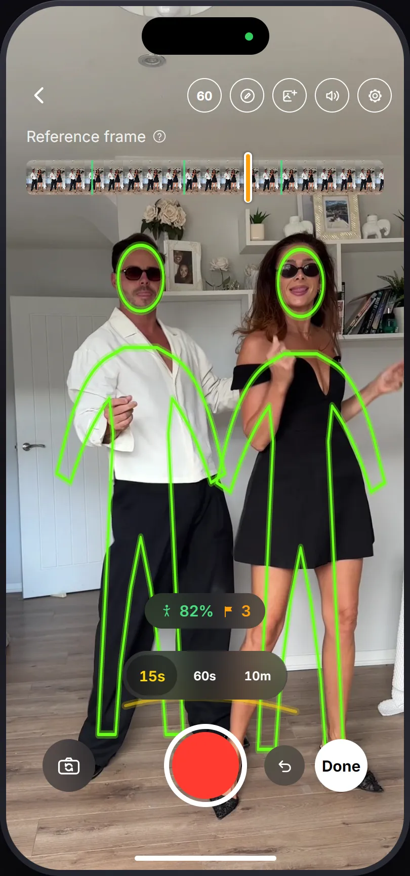 PoseCut's camera on a later take of a two-person shoot: an outline traced over each person from the previous take, the reference scrubber above, and a match percentage over the shutter.